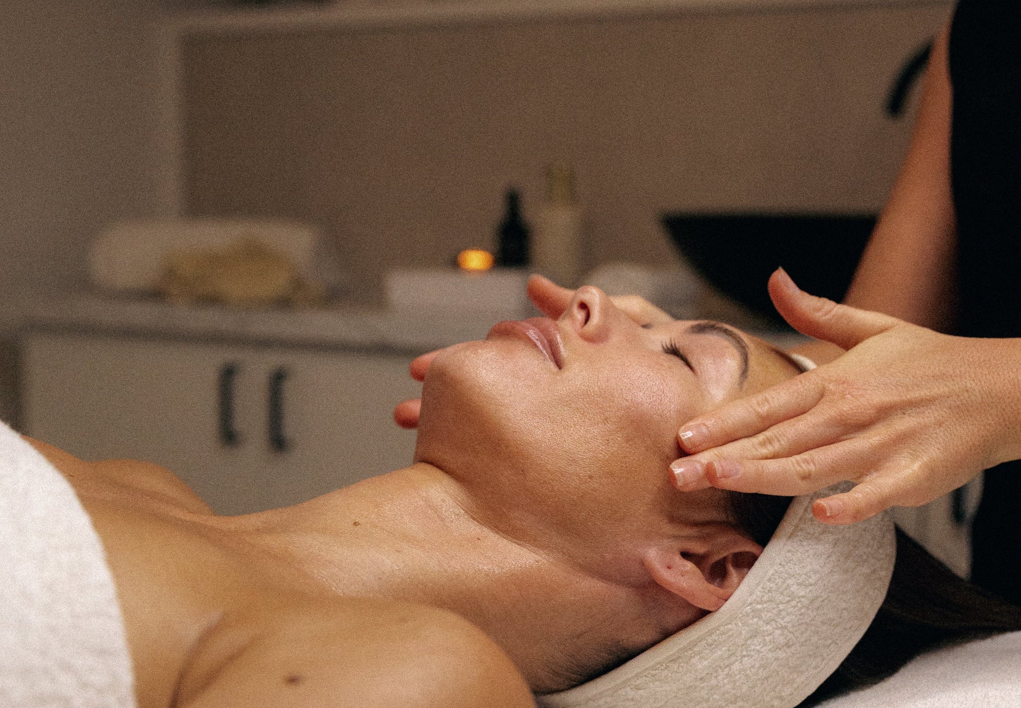Person receiving a facial massage in a spa setting